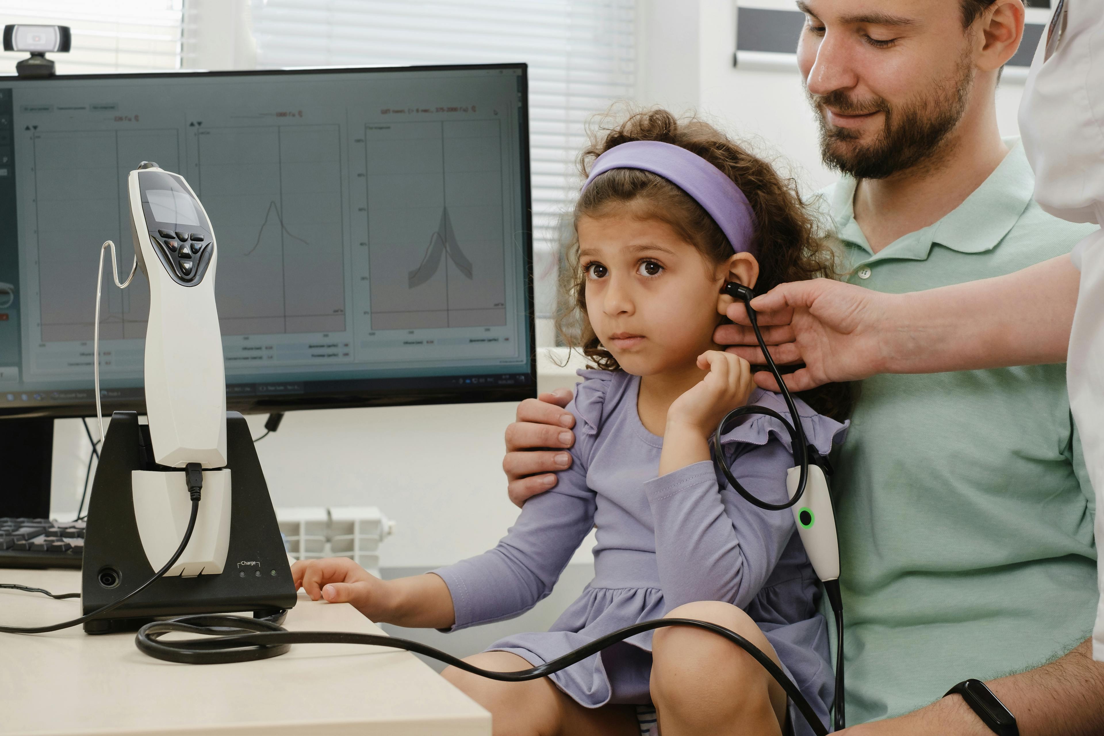 audioprothésiste qui fait un test auditif à un enfant